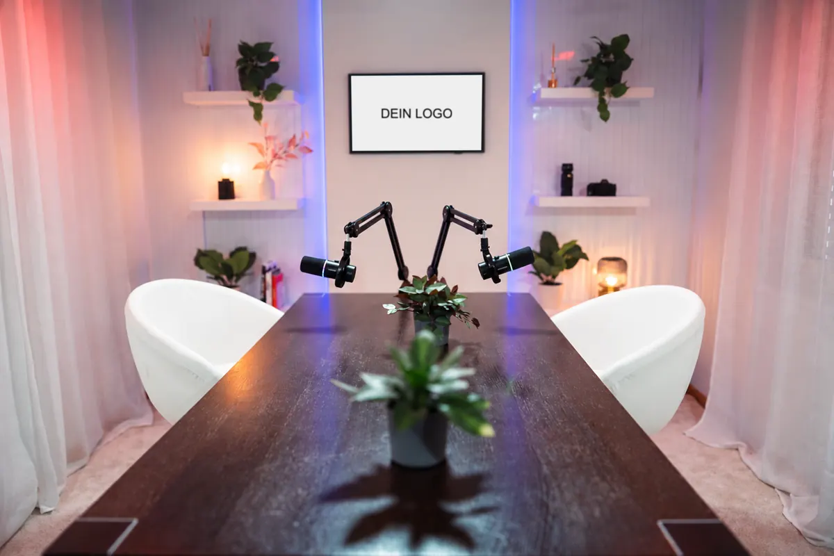 Podcast Setup im Onvitec Content Studio mit zwei weissen Sesseln, zwei Mikrofonen an Schwenkarmen und Bildschirm für euer Logo